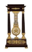 A RARE FRENCH EMPIRE ORMOLU AND FIGURED MAHOGANY OSCILLATING PORTICO MANTEL REGULATOR