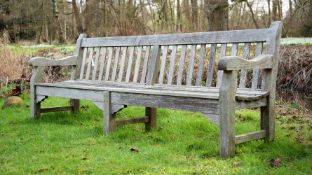 A LARGE WEATHERED HARDWOOD GARDEN BENCH, IN THE MANNER OF R. A. LISTER, 20TH CENTURY