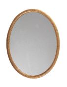 AN IRISH GILTWOOD OVAL WALL MIRROR