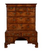 A WALNUT AND FEATHERBANDED CHEST ON STAND
