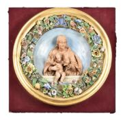 AN ITALIAN GLAZED AND BISCUIT POTTERY RELIEF MOULDED ROUNDEL IN THE DELLA ROBBIA STYLE