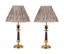 A PAIR OF PARCEL GILT AND PATINATED BRONZE CANDLESTICKS