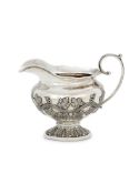 AN INDIAN COLONIAL SILVER OVAL PEDESTAL MILK JUG