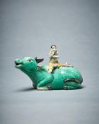 A Chinese biscuit glazed water dropper model of a boy seated on a buffalo