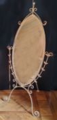 A large oval shaped wrought iron cheval mirror, distressed cream finish 185cms high