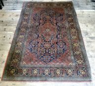 An early 20th century Persian Kashan / Keshan rug in vibrant terracotta, blue and ochre ground