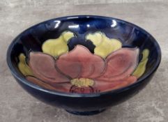 A Moorcroft Clematis pattern pedestal dish, tube lined with a dusty pink flower on a blue ground