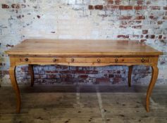 An impressive early 19th century French farmhouse pine double desk, raised on tall cabriole legs,