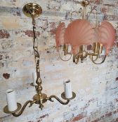 A five-branch chandelier with pink clam shell glass shades; another 3-branch brass chandelier