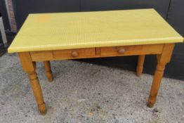 A farmhouse pine side table with two small drawers to frieze, covered in fitted yellow plastic 