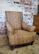 A late Victorian Howard & Sons type armchair re-upholstered in chintz striped fabric, on mahogany