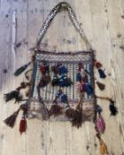 Himalayan Art - a  hand knotted Tibetan textile bag, profusely decorated with geometrical panels and