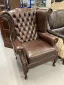20th cent. Thomas Lloyd brown leather wing armchair with Chesterfield style back.