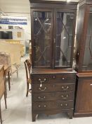 Late 19th cent. Slender mahogany glazed bookcase over four drawer chest, on bracket supports. 30ins.