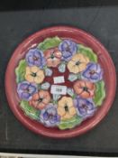 20th cent. Ceramics: Moorcroft plate in the Pansy pattern, on mauve ground. Appears to be a