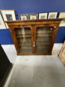 19th cent. Rosewood two door cupboard with glazed doors on a plinth base with two shelves. 48ins.