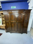 1920s mahogany break front wardrobe with castellated pelmet over four doors decorated with applied