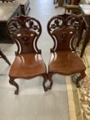 19th cent. Cuban mahogany hall chairs, cabriole legs with pierced scroll shaped backs, a pair.