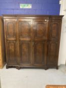 1920s mahogany break front wardrobe with castellated pelmet over four doors decorated with applied