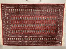 Carpets & Rugs: Late 19th cent. Turkman rug, red ground with a central panel containing sixty guls