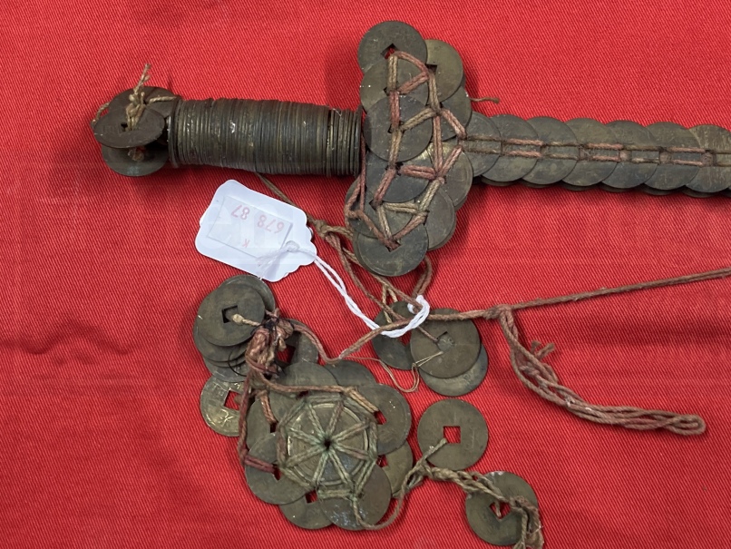 Weapons: Chinese coin sword, iron roil with Chinese coins of the 19th cent. tied to it with red