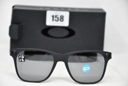 A pair of as new Oakley Apparition sunglasses Satin Black frame with Black iridium Polarized