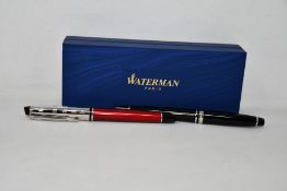 A Waterman Expert Rollerball Pen in black and a Waterman Expert Deluxe Rollerball Pen in dark red,