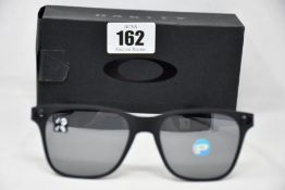 A pair of as new Oakley Apparition sunglasses Satin Black frame with Black iridium Polarized