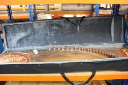 A pre-owned Chinese Guzheng with case and accessories.