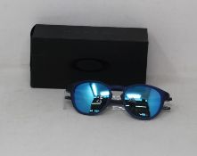 A boxed as new pair of Oakley Pitchman R glasses matte translucent blue frame with Prizm Sapphire
