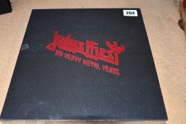 A sealed Judas Priest 50 Heavy Metal Years collectors book.