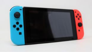 A pre-owned Nintendo Switch handheld games console with neon joy-con pair (no charger).