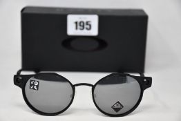 A boxed as new pair of Oakley Deadbolt sunglasses Satin Black frame with Prizm Black Polarized
