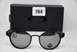 A boxed as new pair of Oakley Deadbolt sunglasses Satin Black frame with Prizm Black Polarized