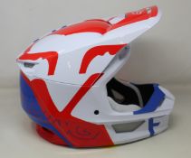 A boxed as new Fox Racing V1 Skew MIPS Motocross Helmet (White, red and blue, Large).