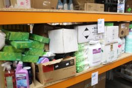 A shelf containing cleaning products to include washing up liquid, sanitisers and toilet rolls.
