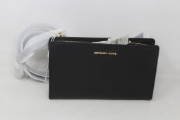 An as new Michael Kors Jet Set travel crossbody clutch bag in black leather.