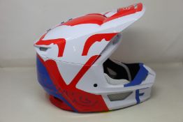 A boxed as new Fox Racing V1 Skew MIPS Motocross Helmet (White, red and blue, Large).