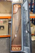 A pre-owned Chinese Guzheng with case and accessories.
