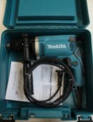 A cased as new Makita hammer drill (HP1631K) (UK adaptor required) (Unrelated sticker to front of