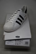 A pair of as new Prada Adidas Superstar sneakers (UK 11).