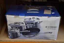A Le Creuset 3-ply stainless steel 4-piece saucepan set.