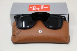 A pair of as new Ray Ban Wayfarer sunglasses.