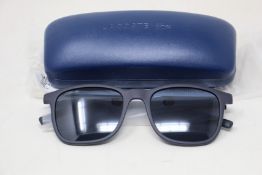 A pair of as new Lacoste sunglasses.