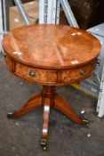 A small circular drum table, Walnut (Item has some minor damage).