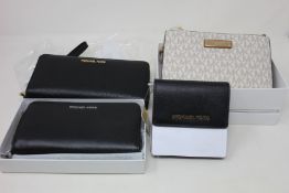 Three as new Michael Kors purses and a card holder.