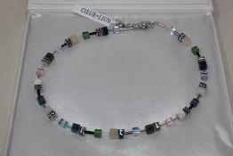 A boxed as new Coeur De Lion GeoCUBE Necklace with Swarovski crystals & gemstones in blue-green.