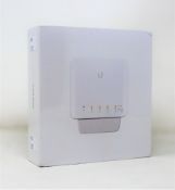 A boxed as new Unifi USW-Flex network switch in white.