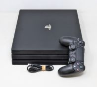 A pre-owned PlayStation 4 console with 1TB storage and controller in black.