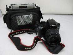 A pre-owned Canon EOS 100D camera with charger and case and a Canon Powershot SX240HS with charger.
